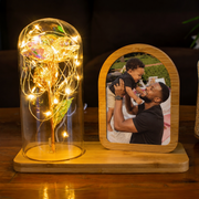 Decorative lamp with string lights and a photo frame with a father and child picture on a wooden surface.