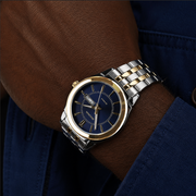 Luxury watch with a blue face and gold accents on a wrist.