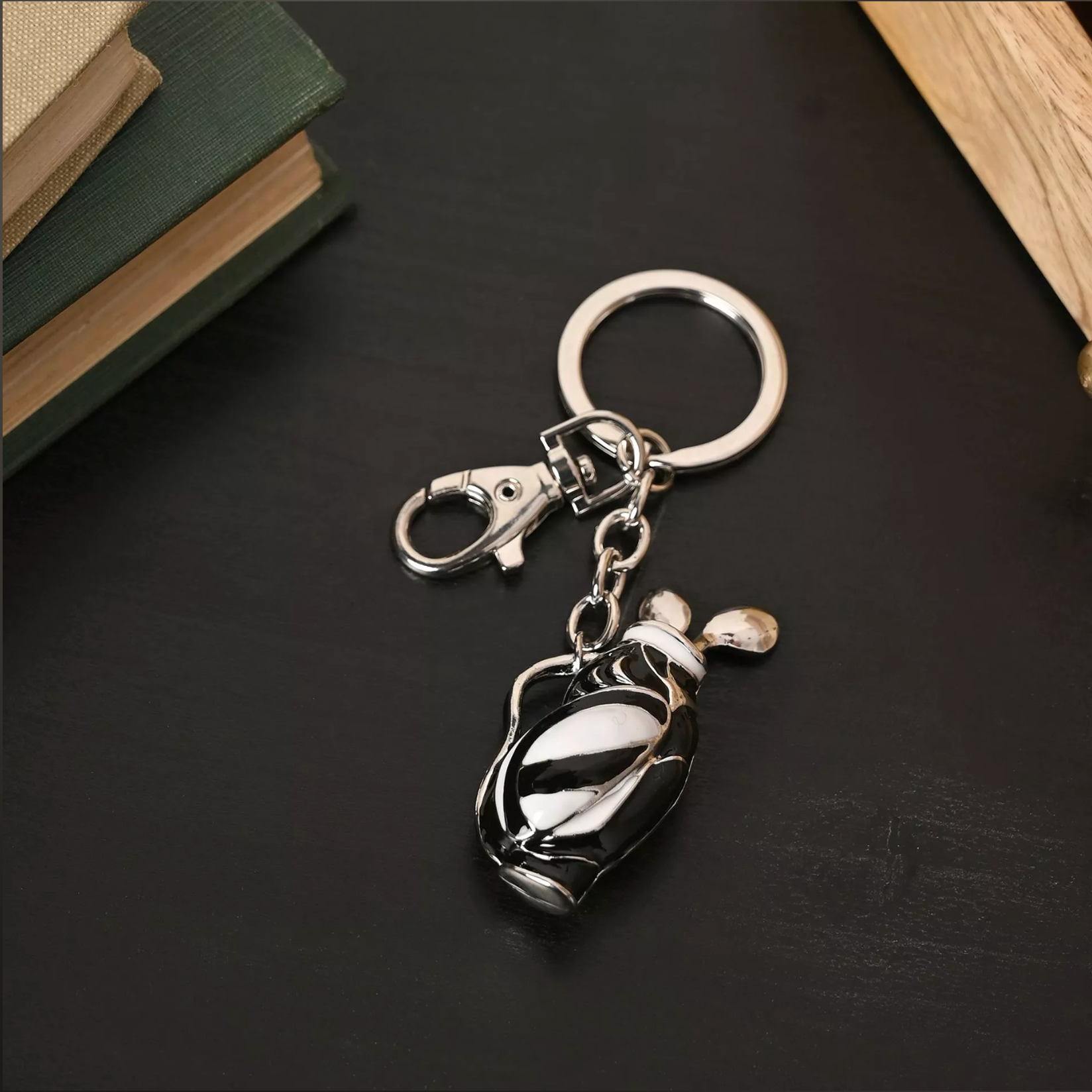 Keychain with golf bag and club design on a dark surface
