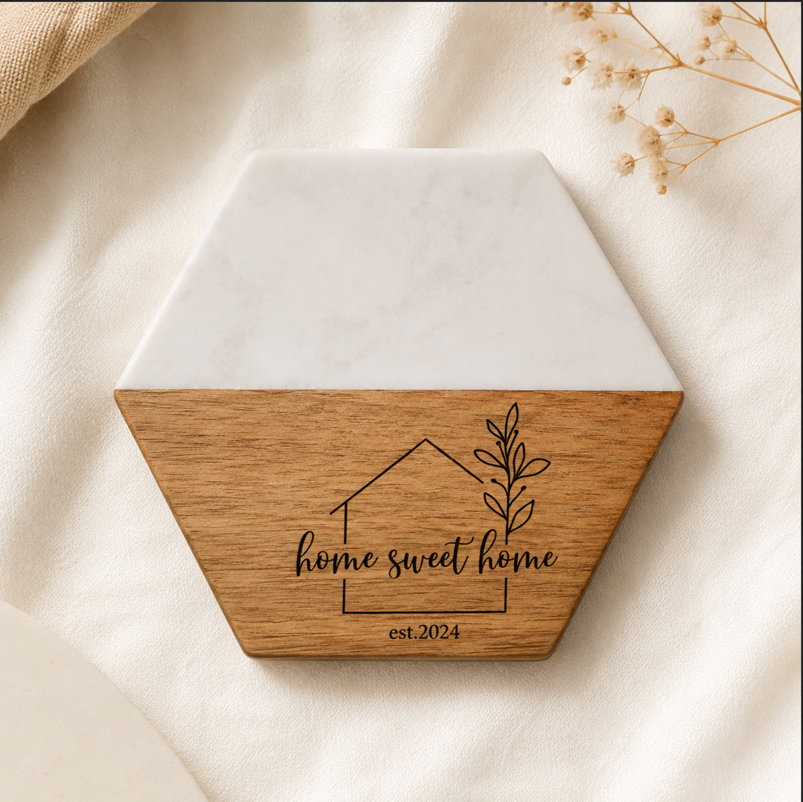 Hexagonal wooden and ceramic decorative item with 'home sweet home' text on a beige fabric background