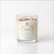A luxury crystal candle in a clear glass jar with a white label reading 'MOM' and 'Purpink' at the top, decorated with dried rose petals on a white background.