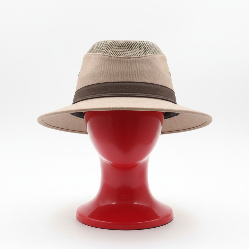 Beige hat with mesh and brown band on a blurred indoor background