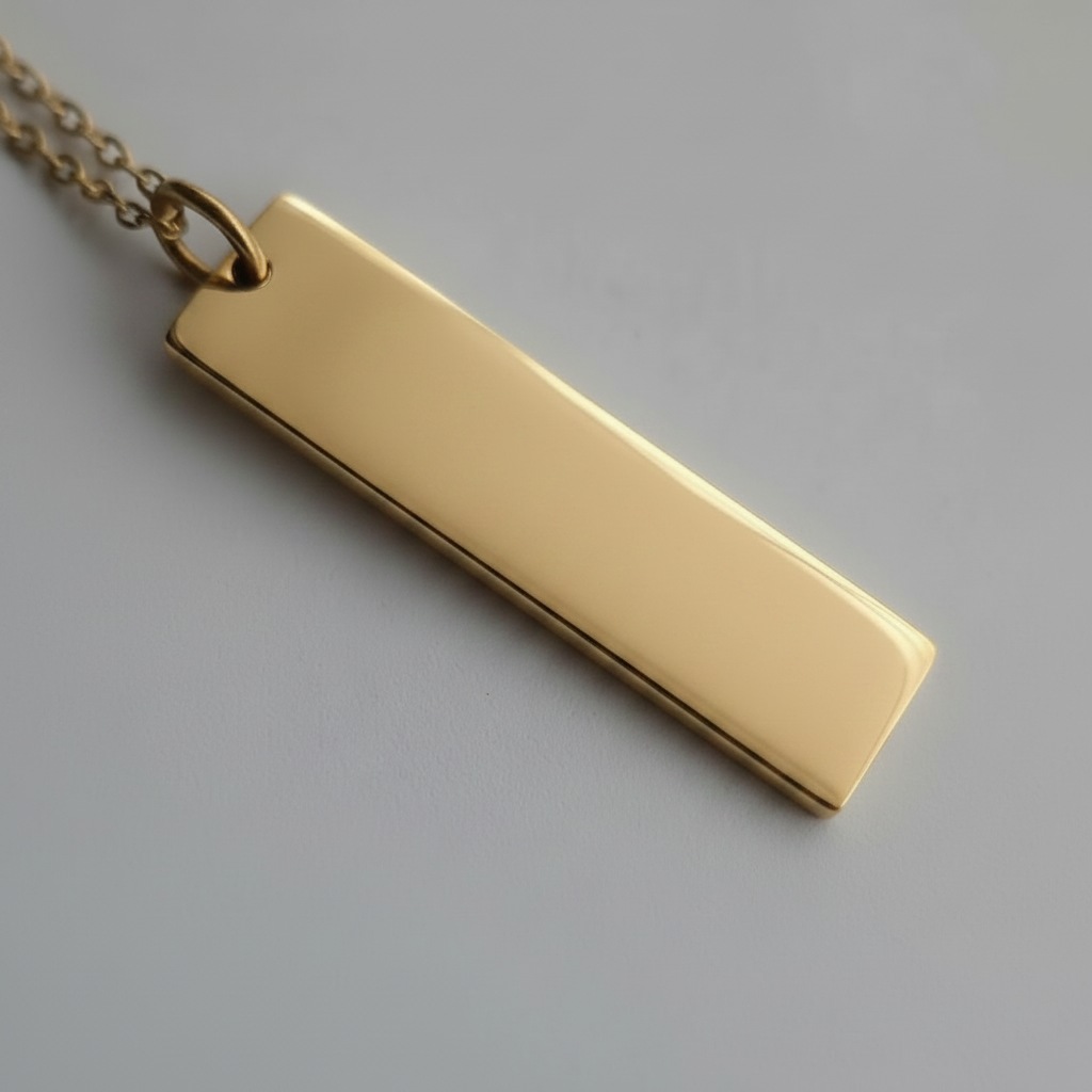 Gold bar pendant on a chain against a gray background