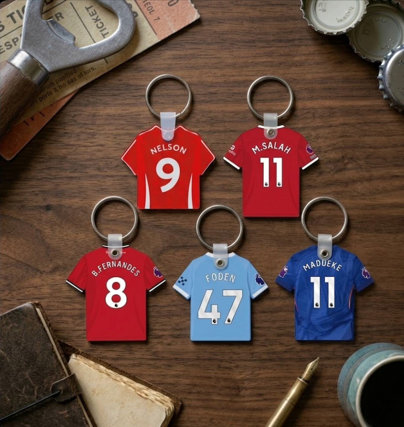 Keychains shaped like red and blue sports jerseys with player names and numbers on a wooden surface.