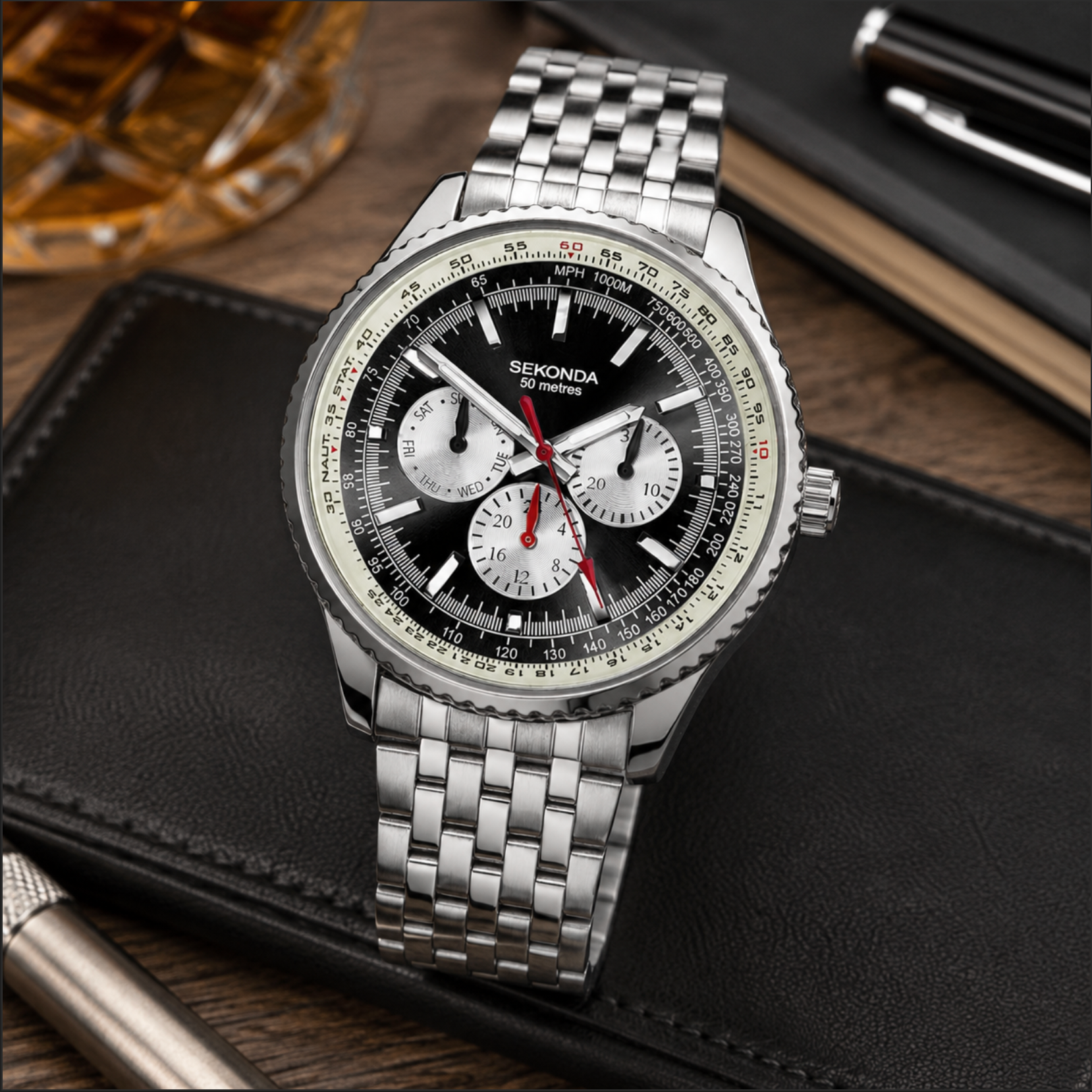 Silver watch with a detailed face on a dark surface