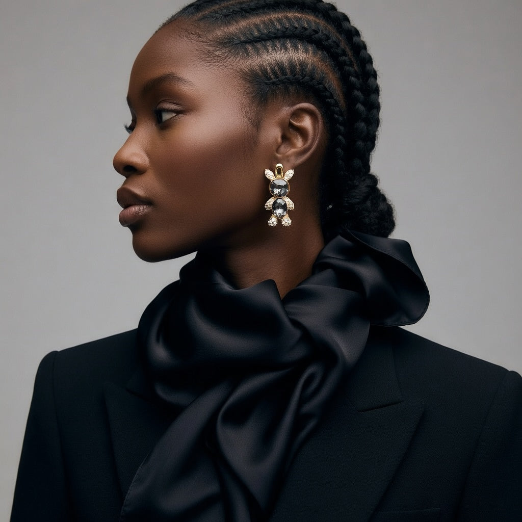 Woman wearing a black scarf and elegant earrings against a gray background