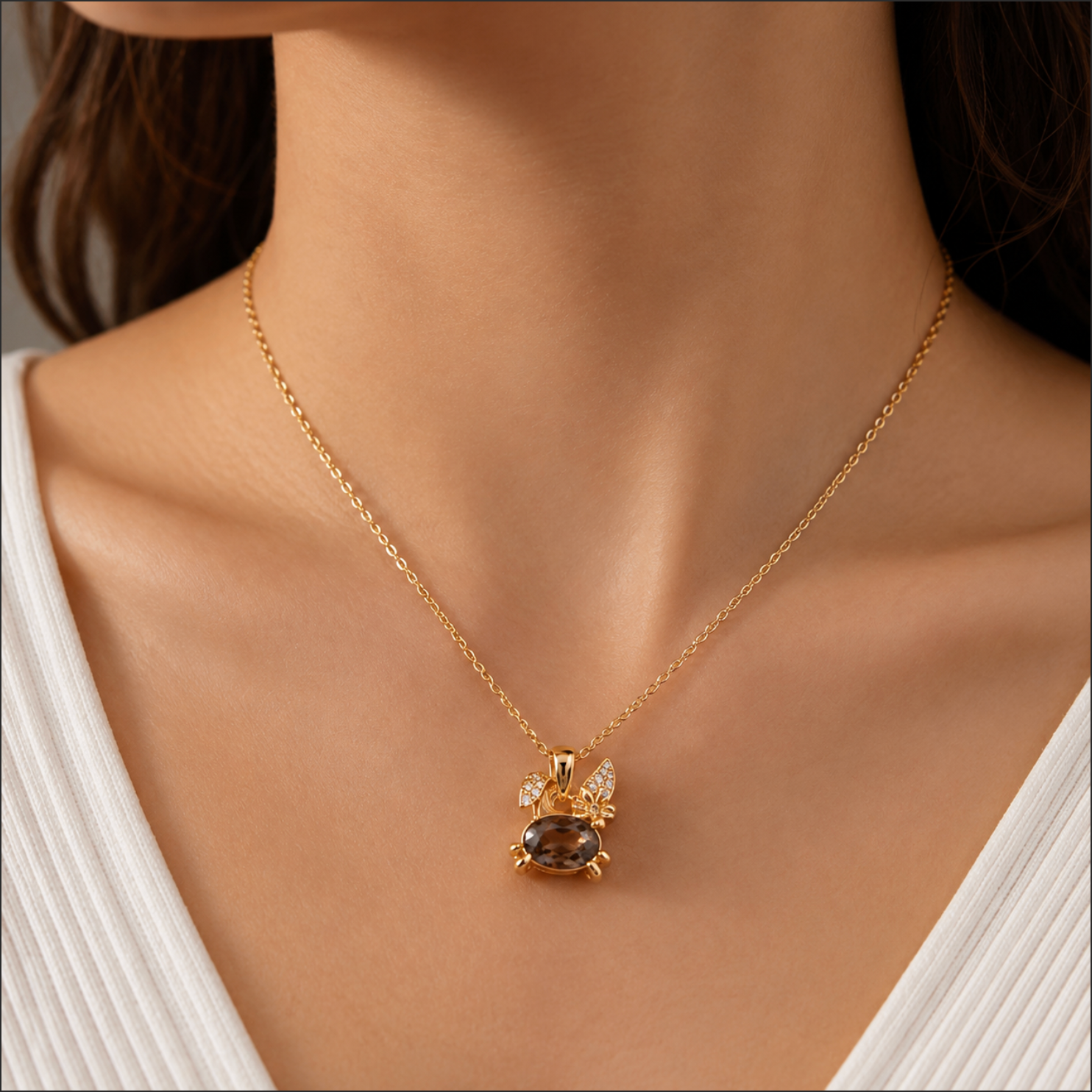 Gold necklace with a pendant on a person wearing a white top