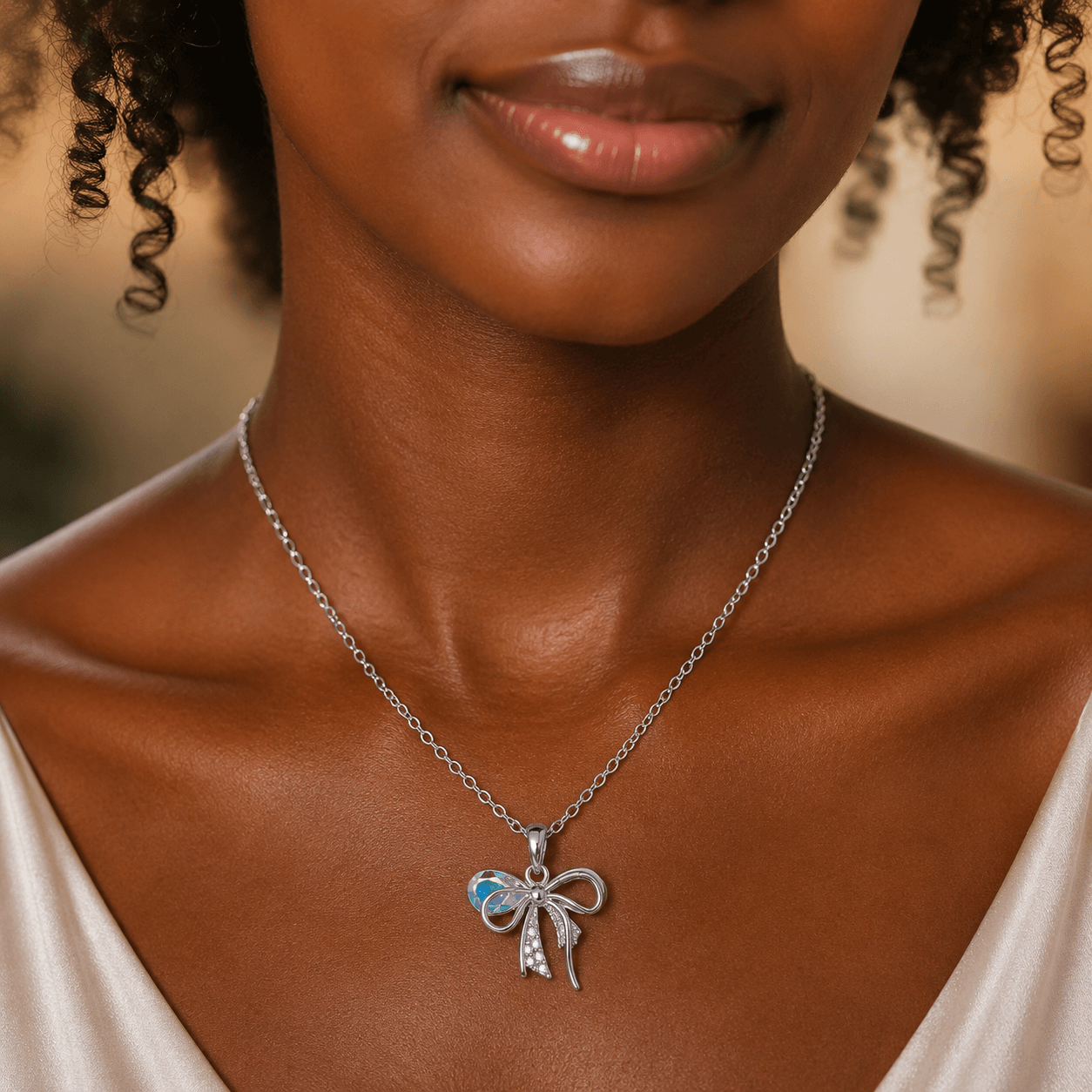 Woman wearing a silver necklace with a bow pendant