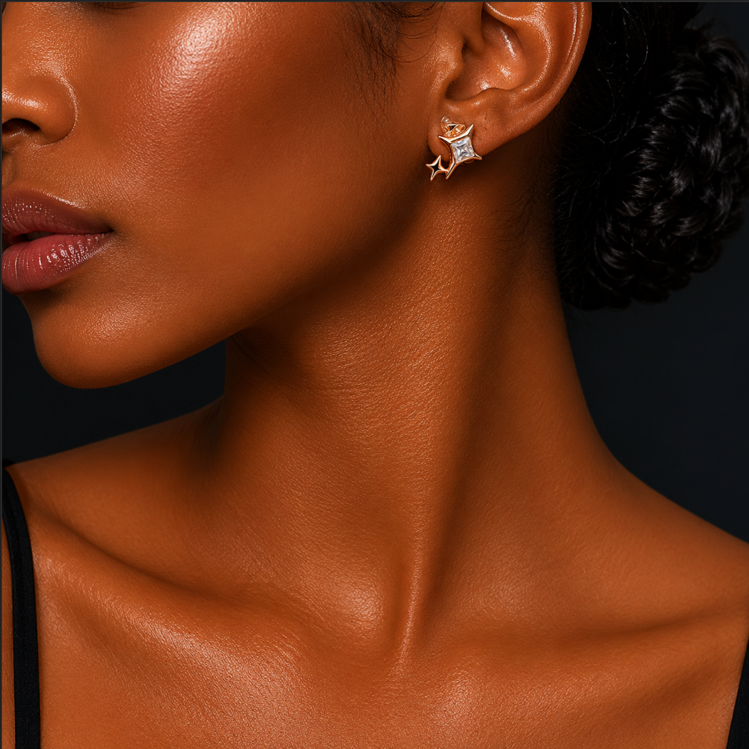 Close-up of a woman's neck and ear with a star-shaped earring against a black background