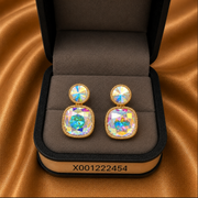 Pair of earrings in a jewelry box on a brown fabric background