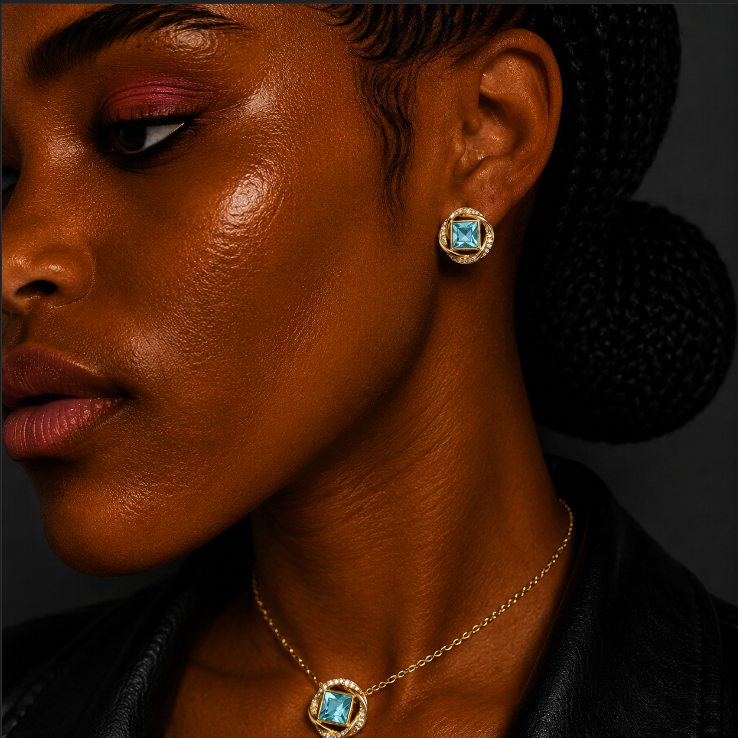Close-up of a woman wearing gold earrings and necklace with gemstones on a dark background