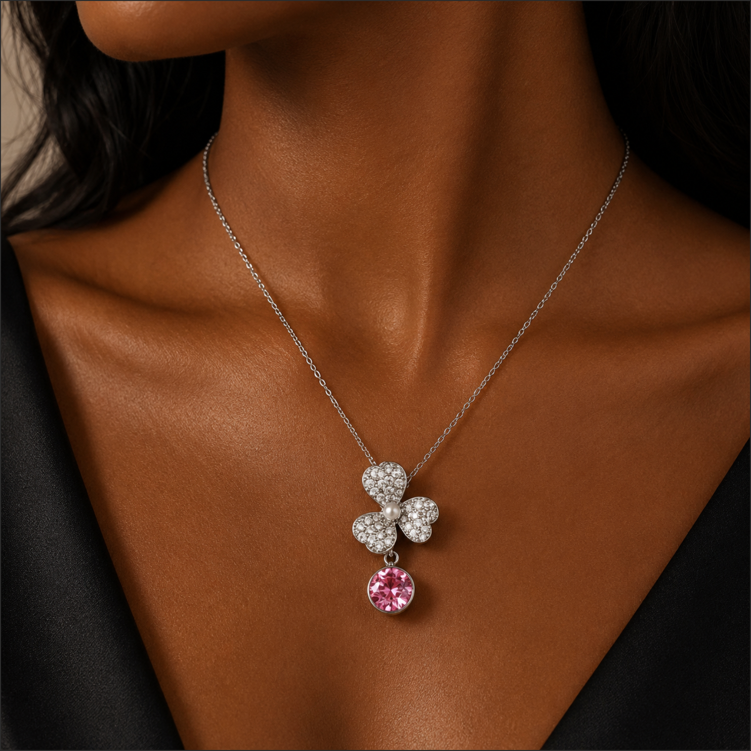 Necklace with a pink and silver pendant on a brown background
