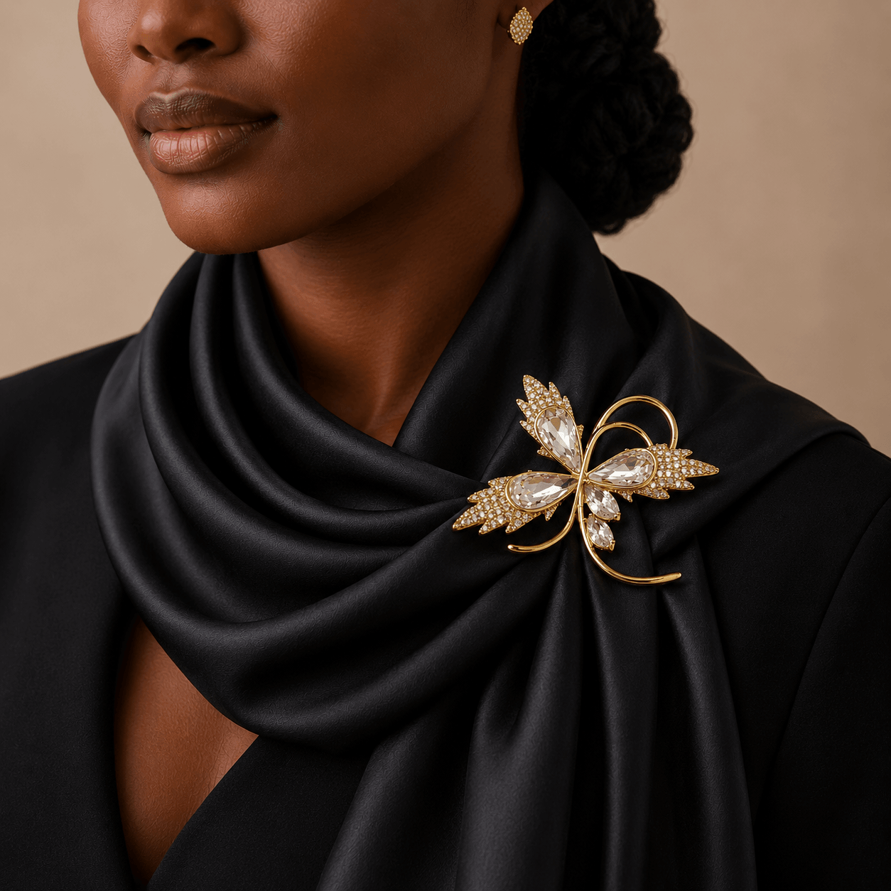 Woman wearing a black scarf with a decorative brooch, against a neutral background