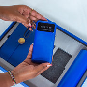 Person holding a blue power bank with digital display on a white background