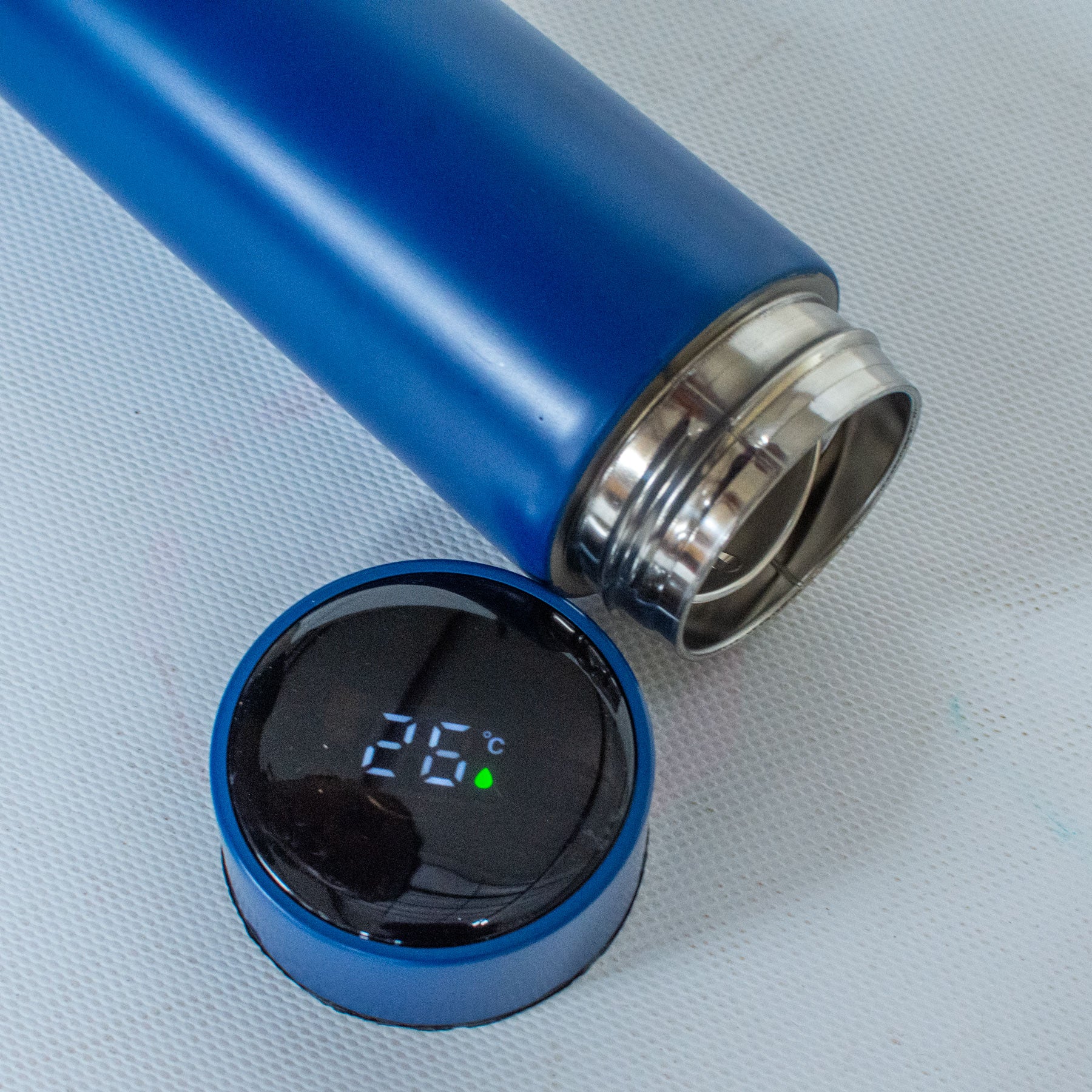 Blue digital thermometer showing temperature on a light gray background